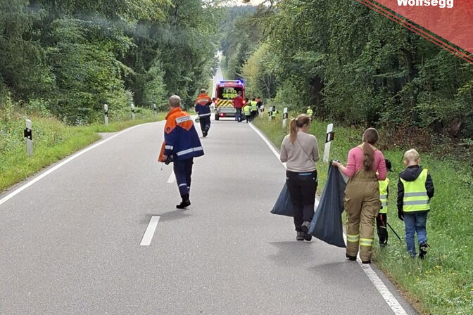 Feuerwehrler der FF Wolfsegg zusammen mit Kindern beim Einsammeln von Müll