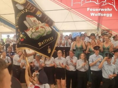 Die Fahne der FF Wolfsegg wird im Festzelt geschwenkt